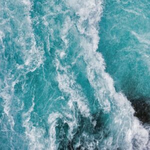 Aerial view of powerful crashing teal and white ocean waves for a coastal feature wall.